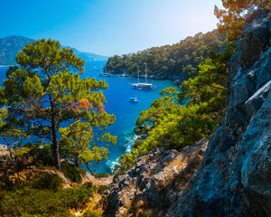 Aegean Sea coast with lush pine trees and calm lagoons with anchored boats, Fethiye, Turkey