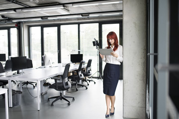 Fototapeta na wymiar Businesswoman with tablet in her office working.