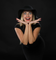 Young happy woman portrait of a confident businesswoman showing by hands on a black background. Ideal for banners, registration forms, presentation, landings, presenting concept