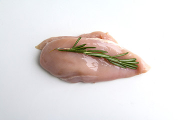 Raw chicken breasts on white with rosemary herb.