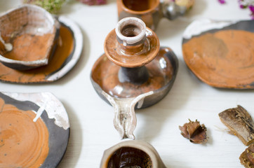 Ceramic set of dishes and cups. Decorative pottery on the wooden table with decorative dried flower