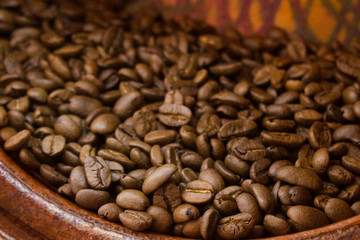 coffee beans inside a brown ceramic pot
