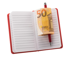 Open blank notebook with ballpoint pen and rolled euro banknote