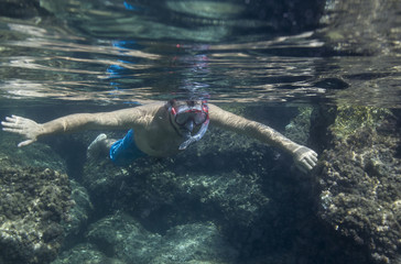 Fototapeta na wymiar Man swimming underwater