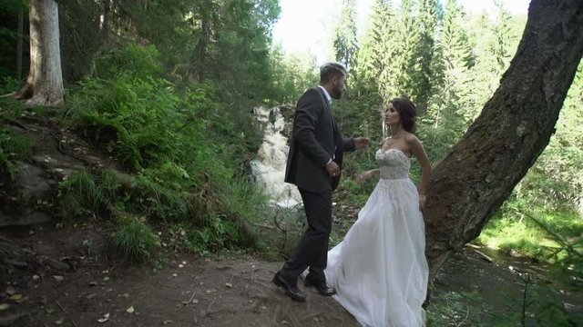 Young couple embracing near waterfall slowmotion