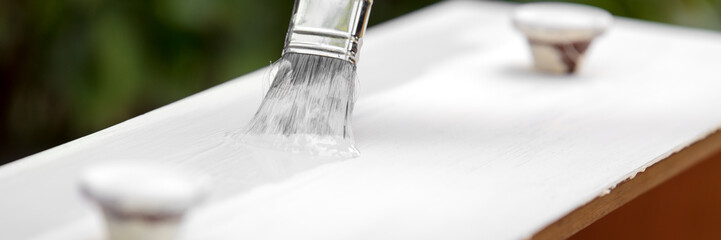 Header, Pinsel mit Farbe Grau beim Streichen von Möbel aus Holz