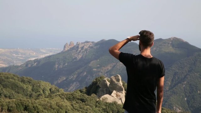 Giovane esploratore guarda il panorama dalla cima di una montagna