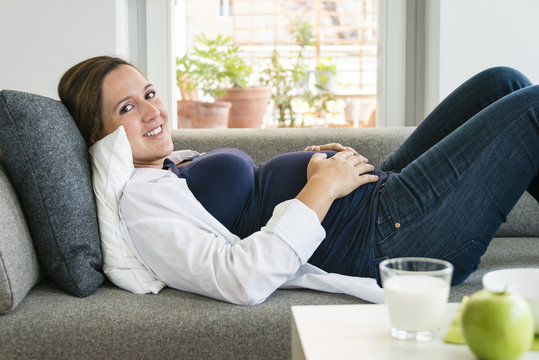 Pregnant woman resting on sofa