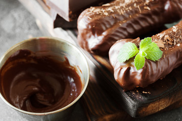 Chocolate eclair decorated with mint and melted chocolate