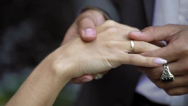 Young wedding couple exchange rings at ceremony near waterfall slowmotion