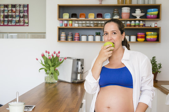 Pregnant woman eating an apple