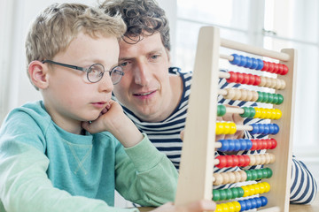 Father and son calculating with abacus