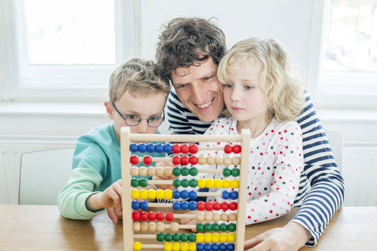 Father and children calculating with abacus