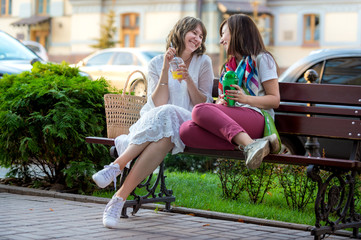 two girls are sitting on the bench