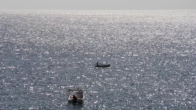 pescatore e natanti in controluce