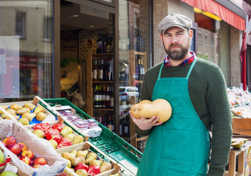 Grocer in front of greengrocer's shop
