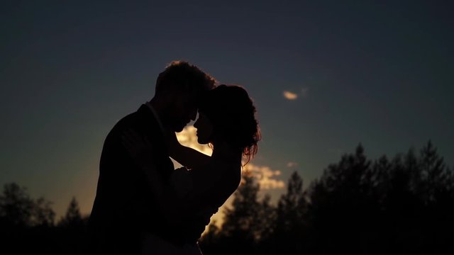 Young lovely couple hugging silhouette slowmotion