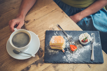Woman drinking coffee and eating sponge cake
