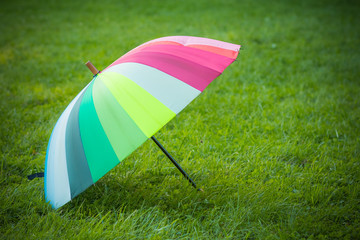 rainbow umbrella on beautiful autumn day. sunny day in park.  Autumn activities, walking in the forest.  protection sun light, high danger uv.