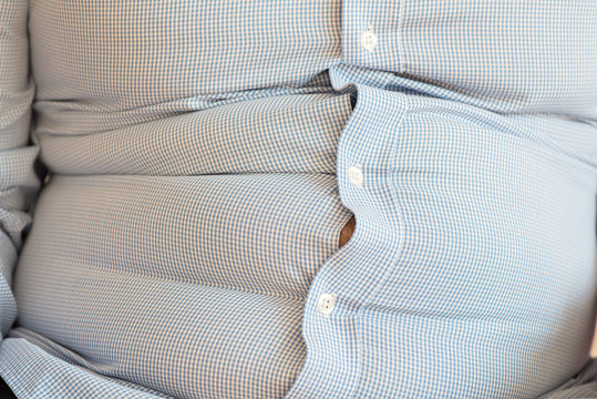 Sitzender Mann mit &Uuml;bergewicht - Fettbauch / K&ouml;rperfett / Gewichtszunahme