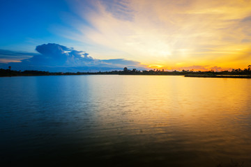 Fototapeta na wymiar Beautiful sunset landscape with blue sky over lake