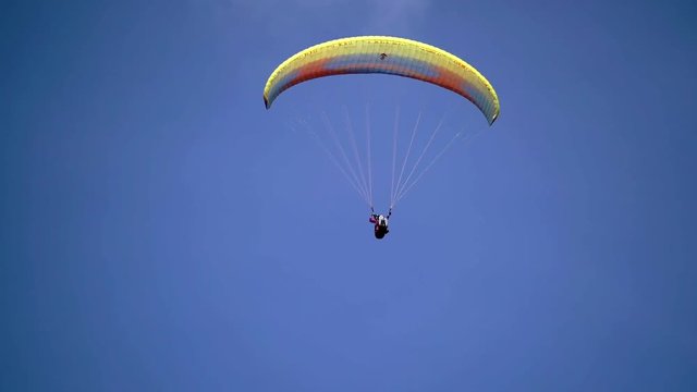 Paraglider flying in the sky at sunny day