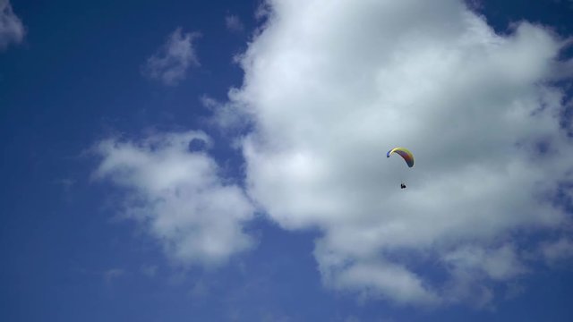 Paraglider flying in the sky at sunny day