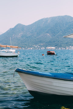 Shot of fishing boats docked in city or town little port in kotor bay in croatia, warm and crystal clear blue waters
