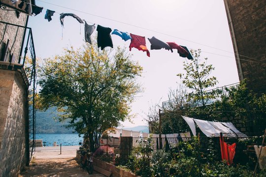 View of cute and rustic old town and garden in between buildings with laundry clothes drying on rope in mediterranean croatian village