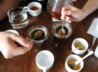 The process of cupping. Tasting freshly brewed coffee with spoons. Coffee accessories on the table