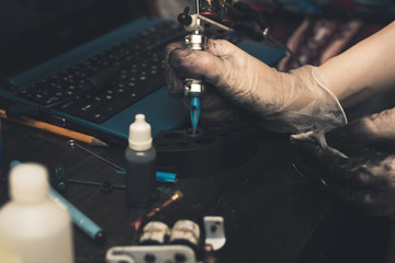 Tattoo. Hands of a tattoo artist up close