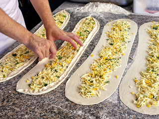mens hands making turkish cake with cheese, greens, corn