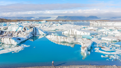 Tourist photographing Icebergs in Jokulsarlon glacial lake, Iceland