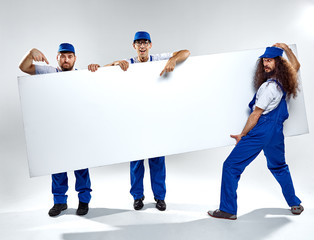 Conceptual picture of three crafstmen holding an empty board