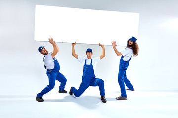 Funny craftsmen lifiting a heavy commercial board - 170318397