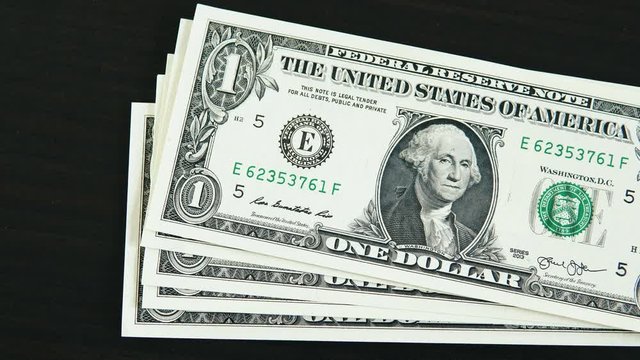 Close-up of a hundred dollar bills fall on a black table. Business stock footage shot. 