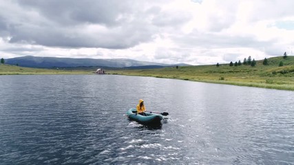Fisherman with his small boat in a misty morning 4k slow motion aerial shot.