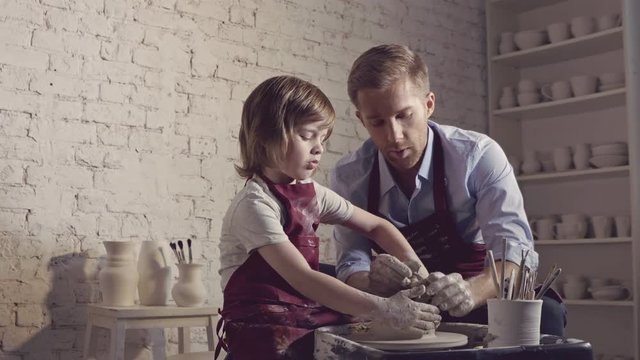 Dad and son at the potter's wheel