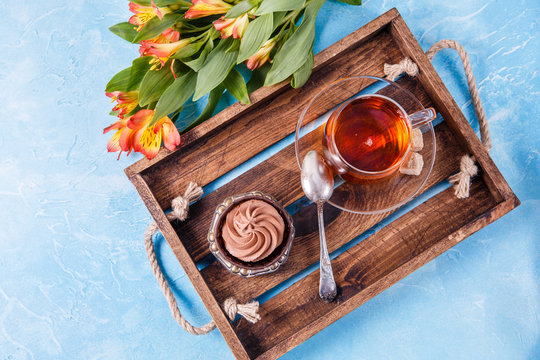 Image of wooden tray with cup,cake with flowers ,