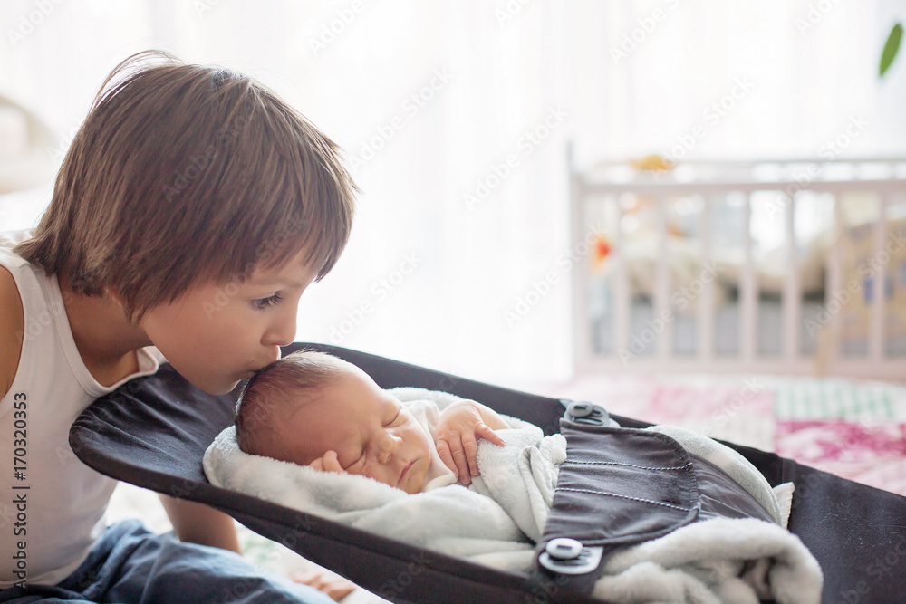 Sticker beautiful boy, hugging with tenderness and care his newborn baby brother at home