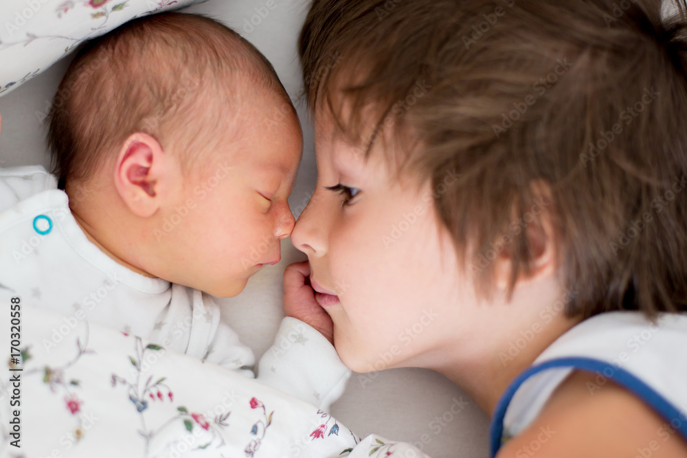 Canvas Prints bbeautiful boy, hugging with tenderness and care his newborn baby brother at home