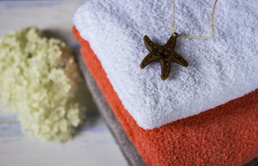 Beautiful bath towels of different colors on a wooden table.