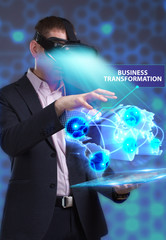 Business, Technology, Internet and network concept. Young businessman working in virtual reality glasses sees the inscription: Business transformation