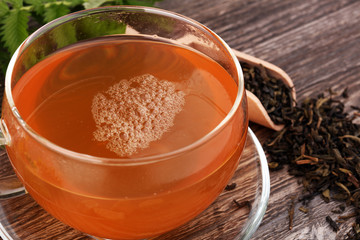 A cup of tea with tea leaves. Tea among the herbs.