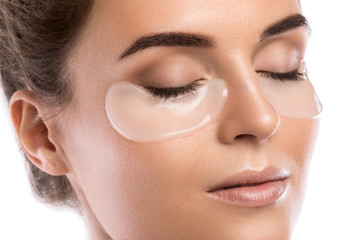 Woman with collagen pads under her eyes - obrazy, fototapety, plakaty