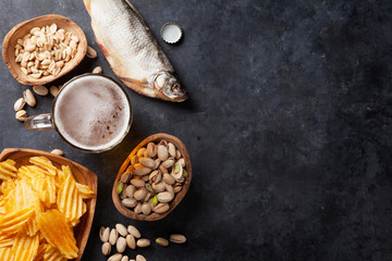 Lager beer and snacks on stone table