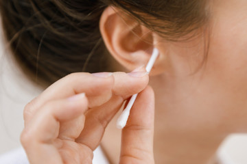 Cleaning ear with a cotton swab