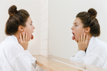 Woman looking on her tongue in the mirror © blackday