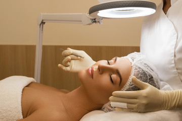 Woman during a mechanical face cleansing procedure