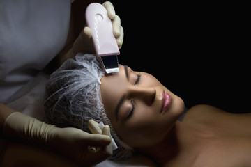 Woman during ultrasonic facial cleansing procedure